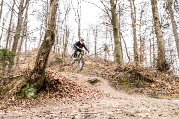 istock Mountain biker jumping over roots in the forest 645125268