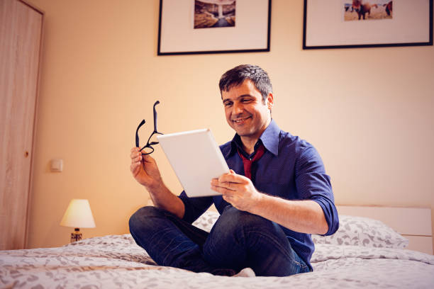istock Businessman working at home,and checking app on digital tablet in bed 645144914