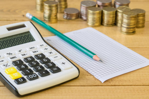 istock Metal coins and calculator on a rustic table. 645145314