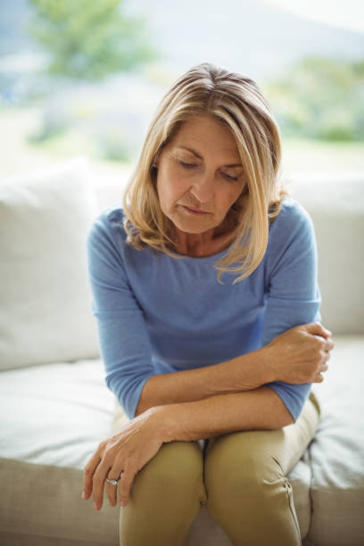 istock Sad senior woman sitting on bed 645164492