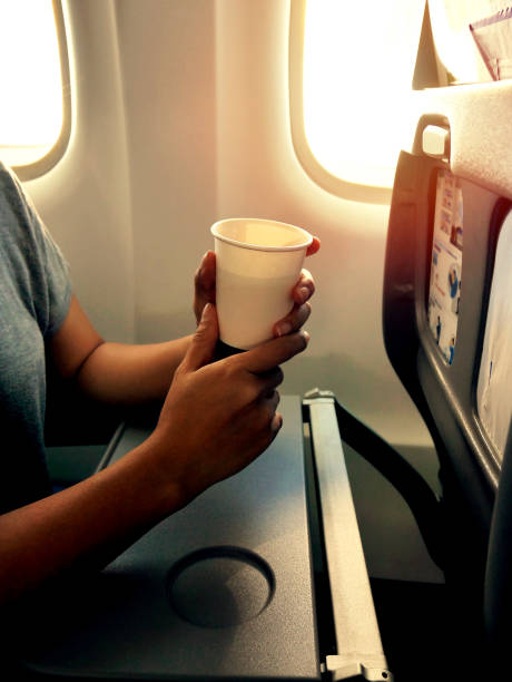 istock Holding a cup of drink in a plane 645164542