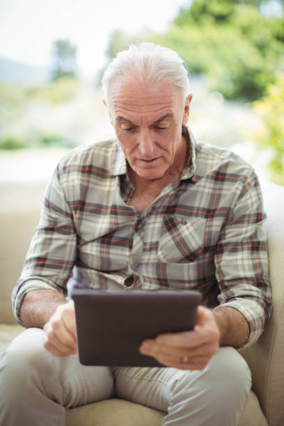 istock Senior man using digital tablet in living room 645165062