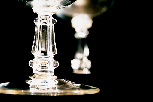 Close up view of crystal stemware glasses on black background.