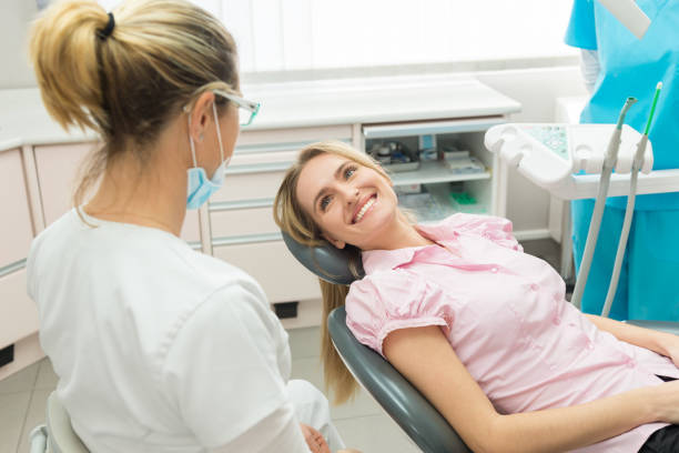 paciente femenino joven sonriendo en el dentista - dentists chair fotos fotografías e imágenes de stock