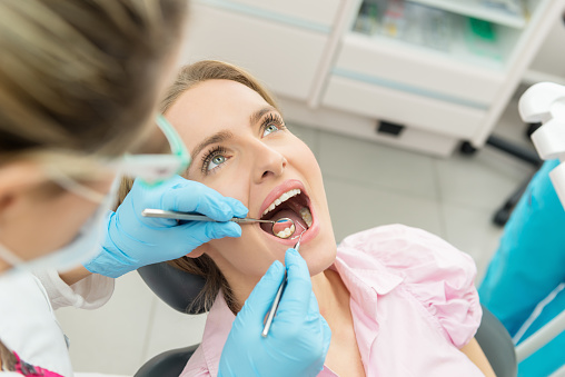 Horizontal color close-up headshot of beautiful woman having dental examination.