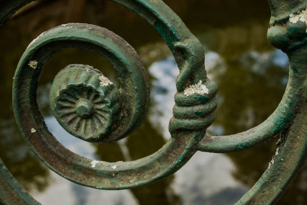 green carved molten iron scroll in the park railing and lake water backgrounds
