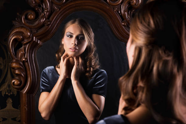 istock Beautiful woman looking at her reflection in mirror 645199326