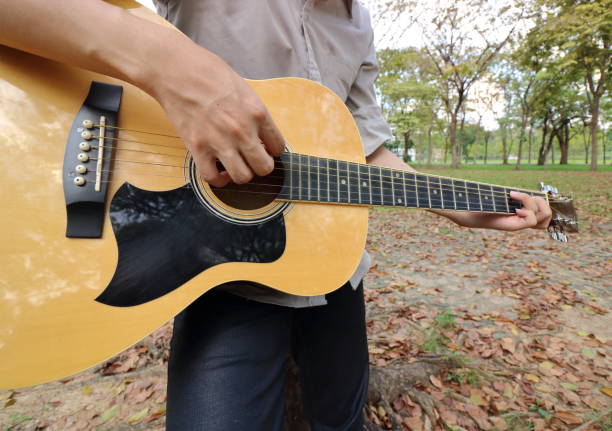 istock Young man is leaning to play  acoustic guitar 645199654