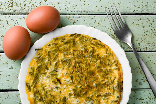Spanish esparragos tortilla, asparagus omelet a spanish tortilla de esparragos, an omelet made with wild asparagus, and some eggs on a pale green rustic wooden table omelet rustic food food and drink stock pictures, royalty-free photos & images