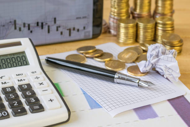 istock Metal coins and calculator on a rustic table. 645210492