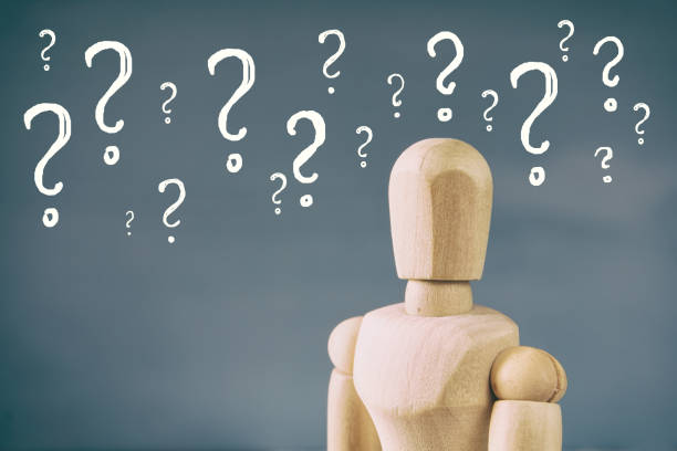 istock image of wooden dummy with may question marks 645215006