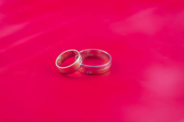 Romanian weddings rings covered in white smoke captured on a red background