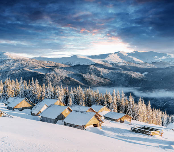 istock Fantastic sunset over snow-capped mountains and wooden chalets 645221090