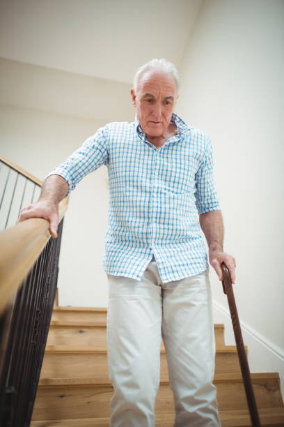 istock Senior man climbing downstairs with walking stick 645224298