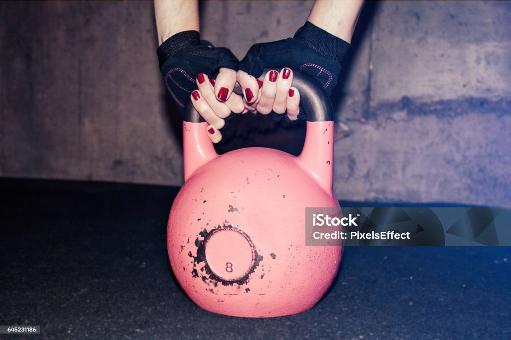 Kettle Bell Held by Woman Cropped shot of female athlete preparing for kettle bell training. Power lifting, weightlifting, workout. fitness, sports concept. Kettlebell Stock Photo