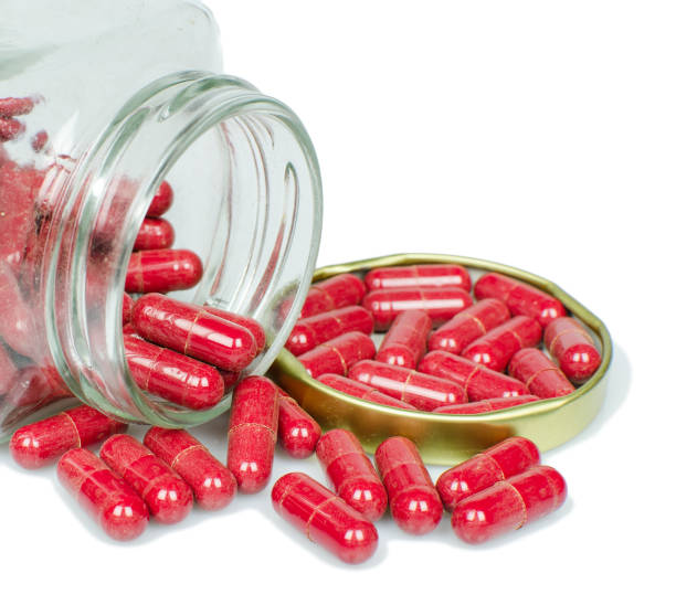 istock Isolated dusted expried old red capsule pills 645236792