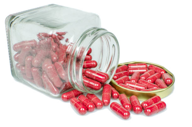 istock Isolated dusted expried old red capsule pills 645237078