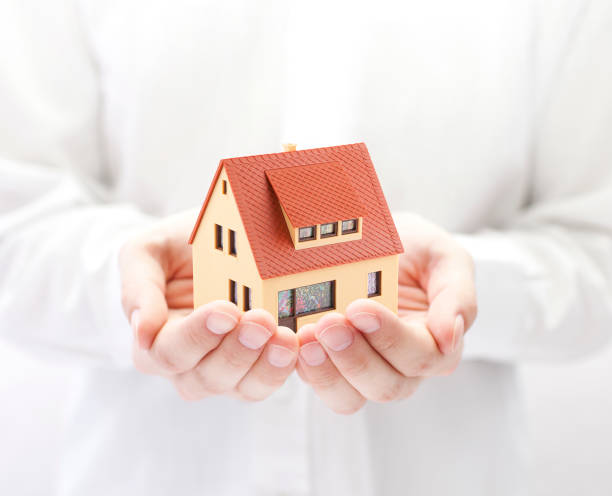 istock Small toy house in hands 645239668