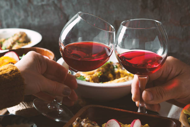 istock Glasses with a drink in his hand and a festive table side view 645240710
