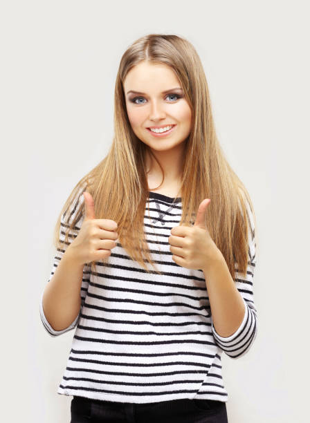 istock Girl laughing at camera with thumbs up. 645255242