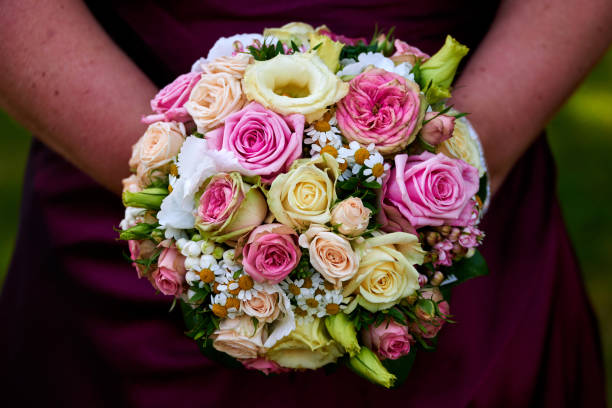 istock bride holding wedding bouquet with roses 645270606