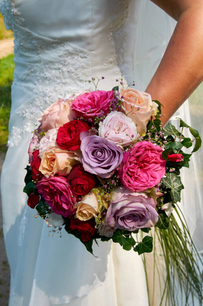 istock bride holding wedding bouquet with roses 645275798