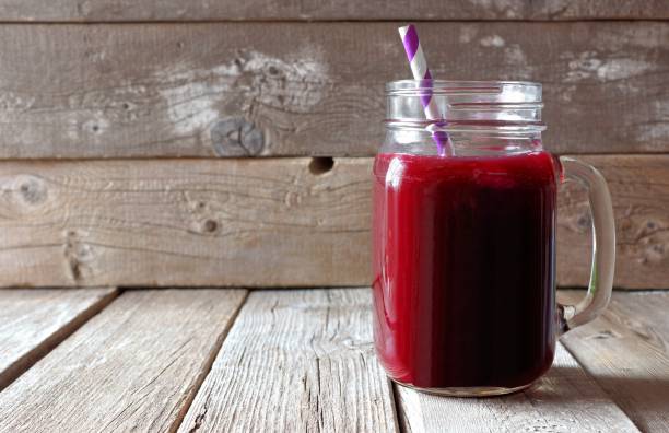 Beet juice in a mason a jar over rustic wood