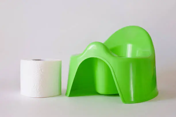 children's green pot and toilet paper on a white background