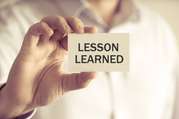 istock Businessman holding LESSON LEARNED message card 645289596