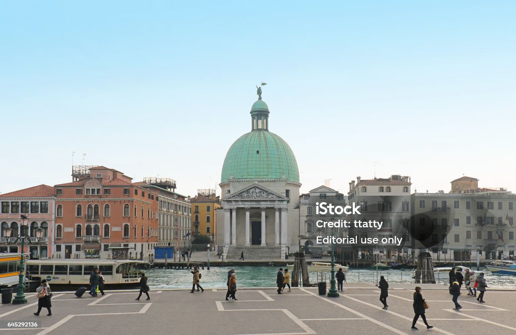 Saint Simeon Piccolo Venice, Italy - January 09, 2017: Tourists walking around large square across the Grand Canal from San Simeone Piccolo church in Venice. San Simeone Piccolo faces the railroad terminal serving as entry point for most visitors to the city. Architecture Stock Photo