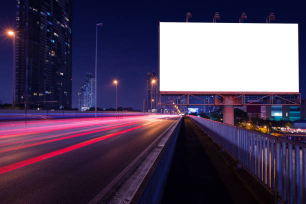 istock blank billboard and light trails night street 645296498