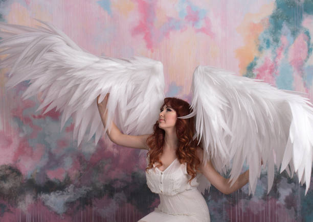 istock model with open angel wings  with pink sky background 645298968