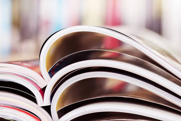 istock stacking of opened magazine with blurry bookshelf background 645301638