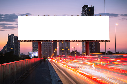 Blank billboard on light trails, street and urban in the evening or twilight - can advertisement for display or montage product or business