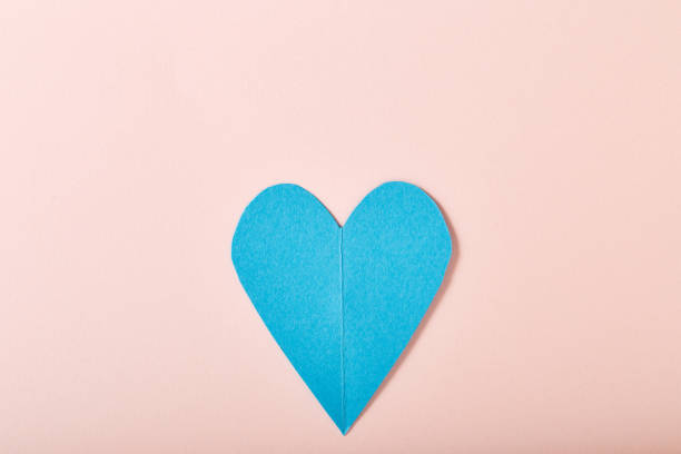 istock Blue paper heart on pink paper 645319648