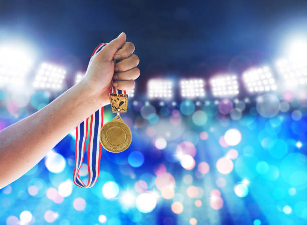 istock Man holding up a gold medal against,win concept. 645322110