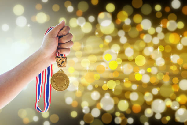 istock Man holding up a gold medal against,win concept. 645322350