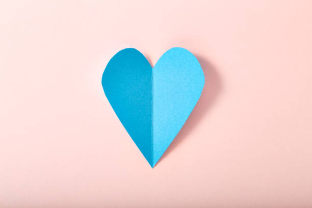 istock Blue paper heart on pink paper 645322690