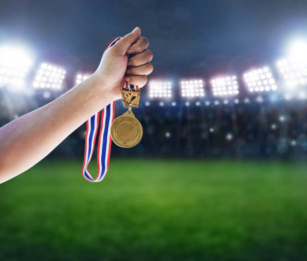 istock Man holding up a gold medal against,win concept. 645324806