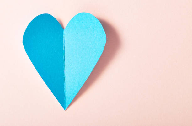 istock Blue paper heart on pink paper 645327994