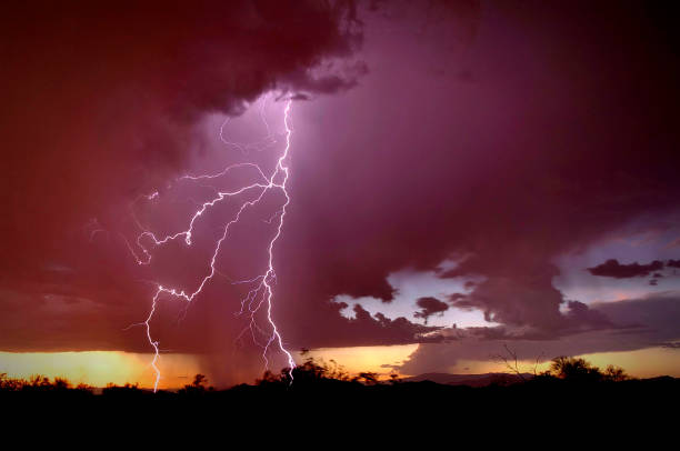 God of Glory Thunders The Power of God in a lightning strike in the Sonoran Desert of Phoenix, Arizona with a dark purple sky and black foreground silhouette. lightning rain thunderstorm storm stock pictures, royalty-free photos & images