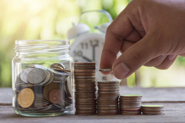 istock Man hand stacking coins put to the bottle 645330978