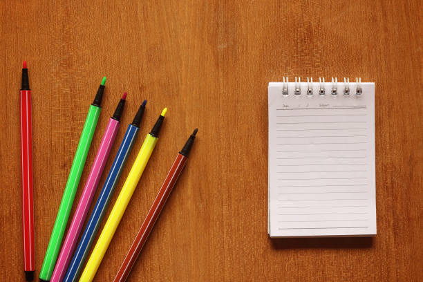 istock notebook and multicolored pens on wooden table 645331054