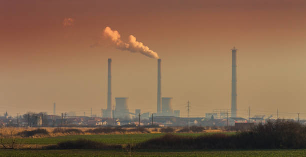 istock Air pollution from coal-powered plant smoke stacks, and industrial cityscape 645331400