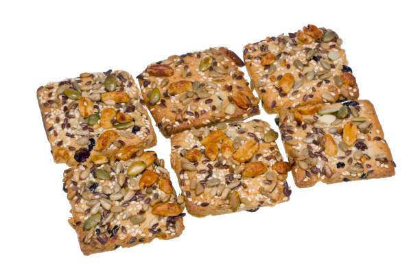 istock Square cookies crackers with raisin. Fried nuts, a peanut, a gingelly and seeds a sunflower increase taste and saturate with vitamins. Isolated 645335094