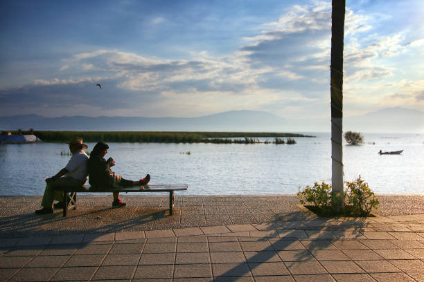 Chapala, Mexico - December 27, 2016: A couple relaxes during the sunset near the pier in Lake Chapala, Mexico's largest freshwater lake.