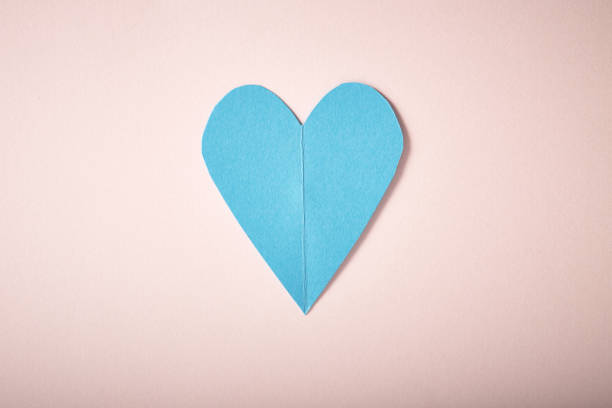 istock Blue paper heart on pink paper 645343894