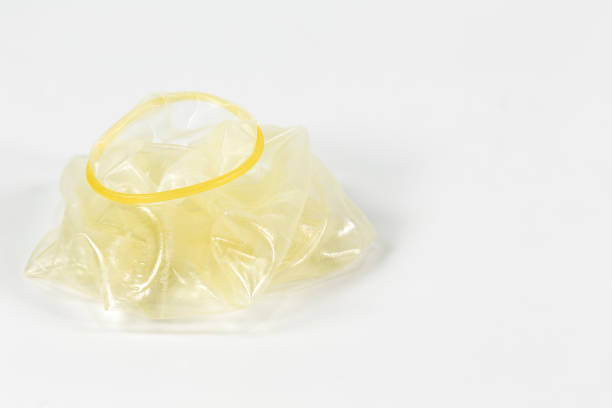istock a rolled-off condom on the left isolated on white background 645344582