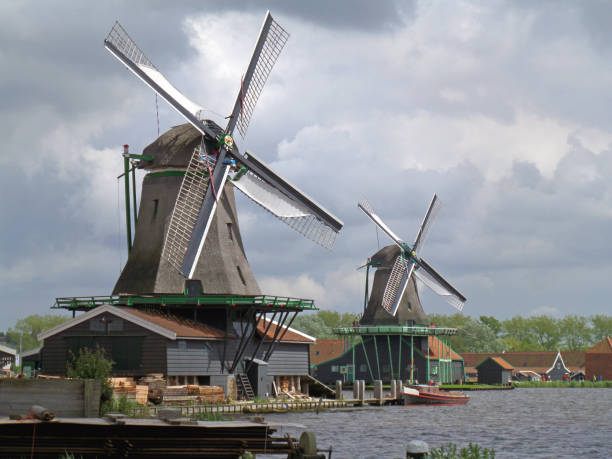 istock Two traditional Dutch windmills against Cloudy Sky 645347182