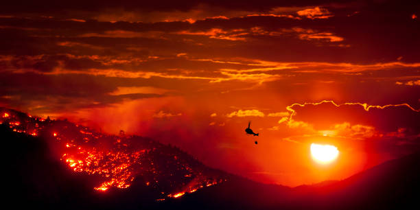 brennendes wildfeuer bei sonnenuntergang - hill dusk sunset heat haze stock-fotos und bilder